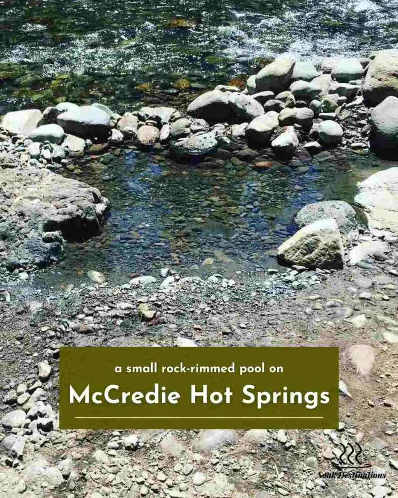 4 compressed - soakdestinations Clear shallow water fills a small rock-rimmed pool on the sunny riverbank at McCredie Hot Springs.