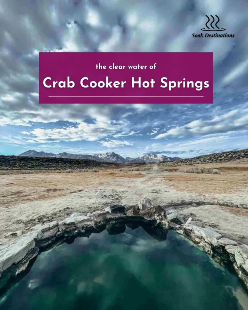Crab Cooker Hot Springs 5 1 - soakdestinations Clouds reflect in the clear water of Crab Cooker Hot Springs with snowy mountains behind.