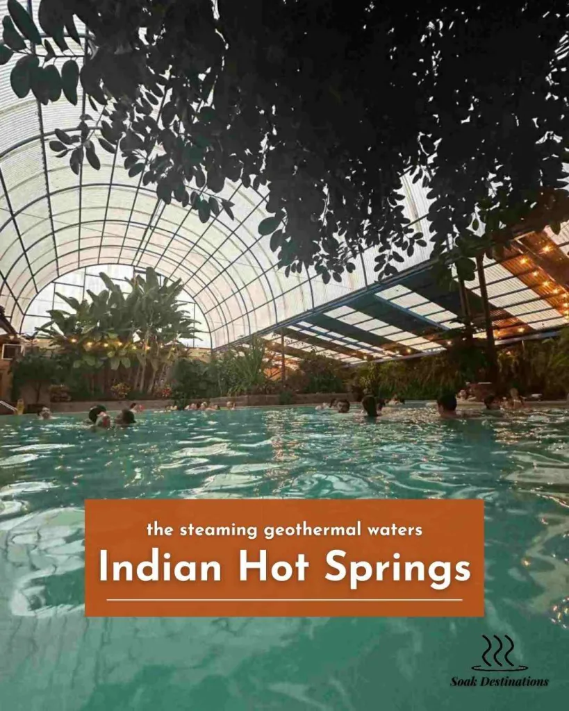 People relax in the steaming geothermal waters under the lush greenhouse canopy at Indian Hot Springs.