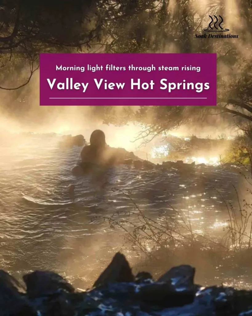 Morning light filters through steam rising from a person soaking in the Valley View Hot Springs.