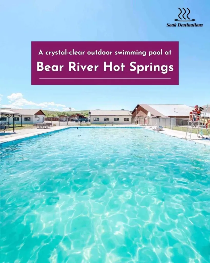 A crystal-clear outdoor swimming pool at Bear River Hot Springs under a bright blue sky.