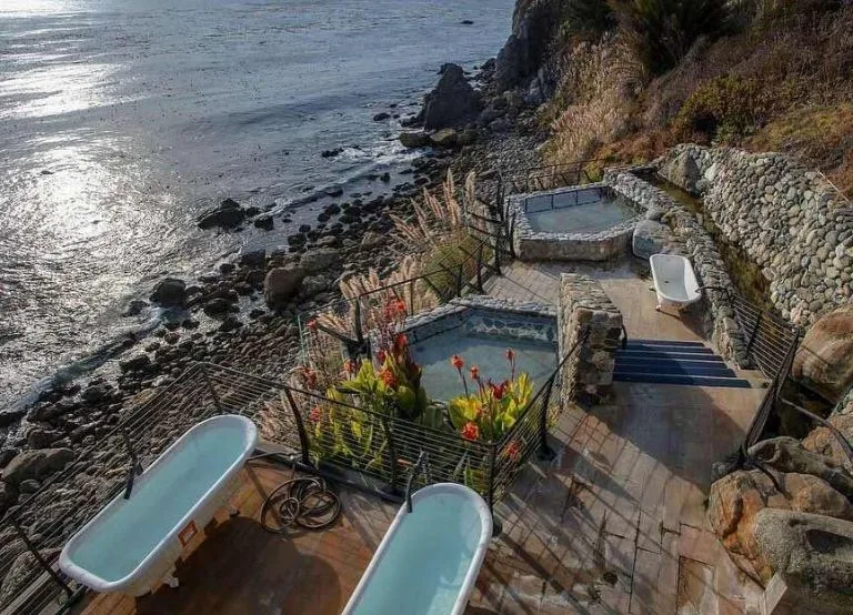 Cliffside stone tubs overlooking ocean waves at Esalen Hot Springs.