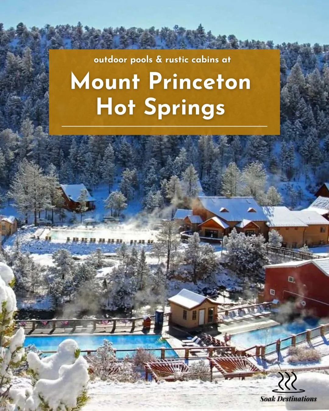 A snowy winter landscape features steaming outdoor pools and rustic cabins at Mount Princeton Hot Springs.