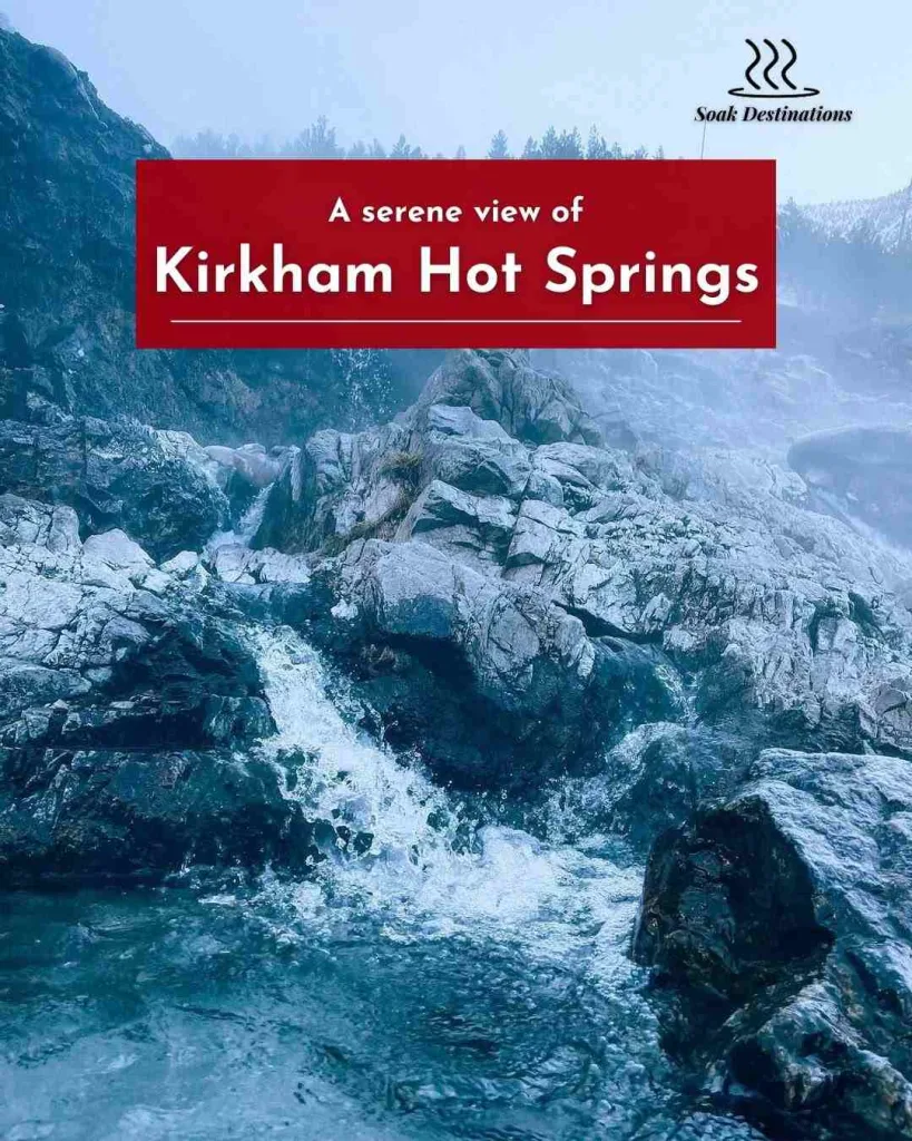 A serene view of Kirkham Hot Springs, with mist rising from the rocky terrain.
