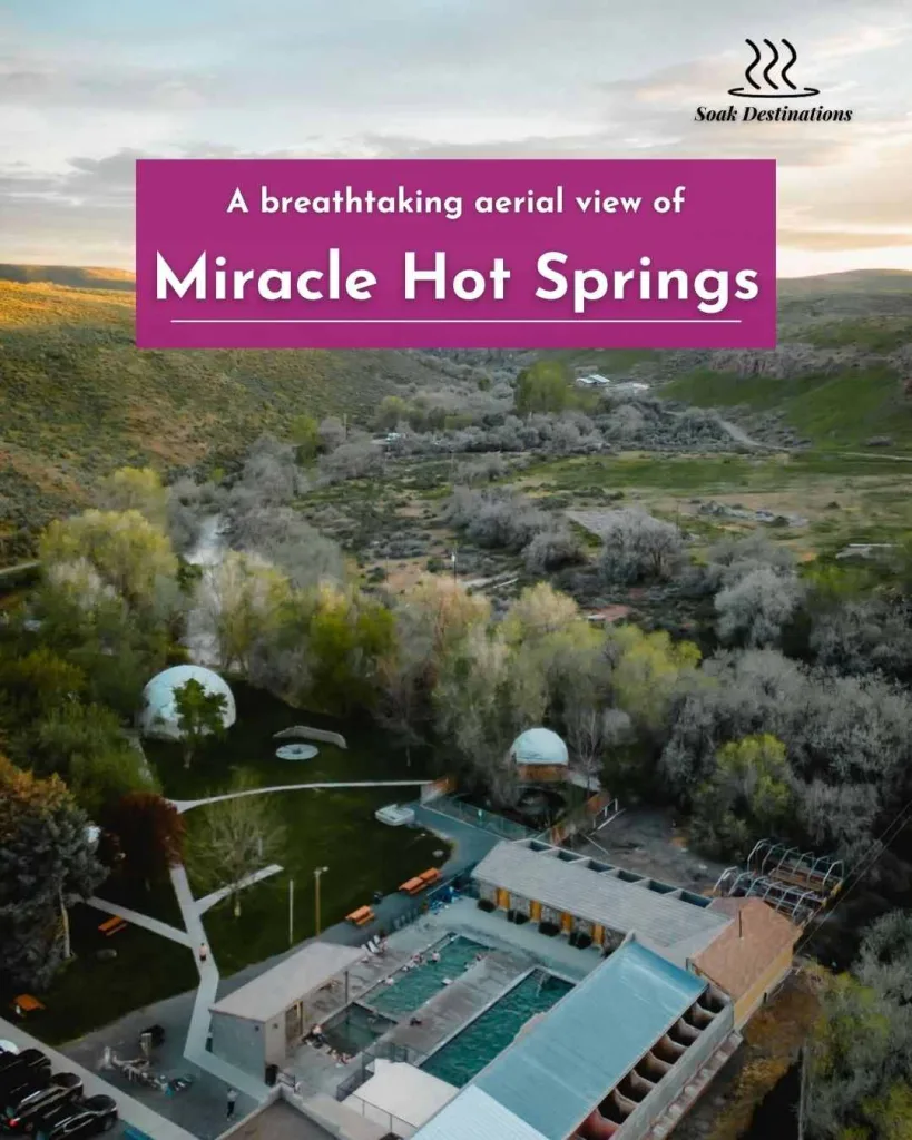 A breathtaking aerial view of Miracle Hot Springs, surrounded by lush greenery and mountains.